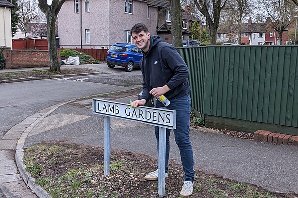 Aiden Wells cleaning road sign